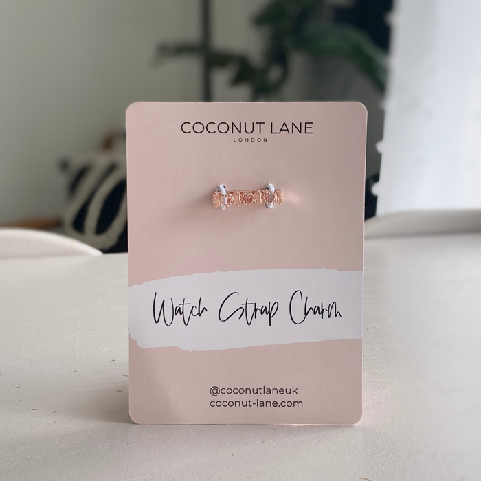 Rose gold crystal heart watch strap charm by Coconut Lane on a display card, set against a white background.